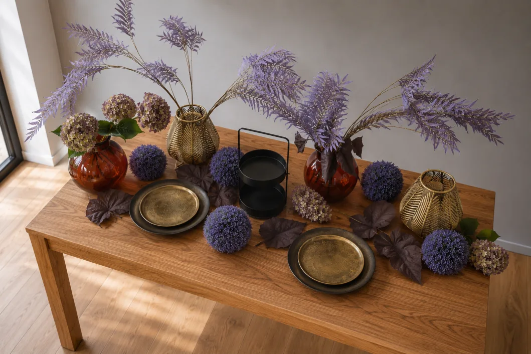 Die Tafel Purple Rain von schräg oben, mit Goldtellern, Alliumkugeln und dunkelroten Blättern zwischen den Vasen.
