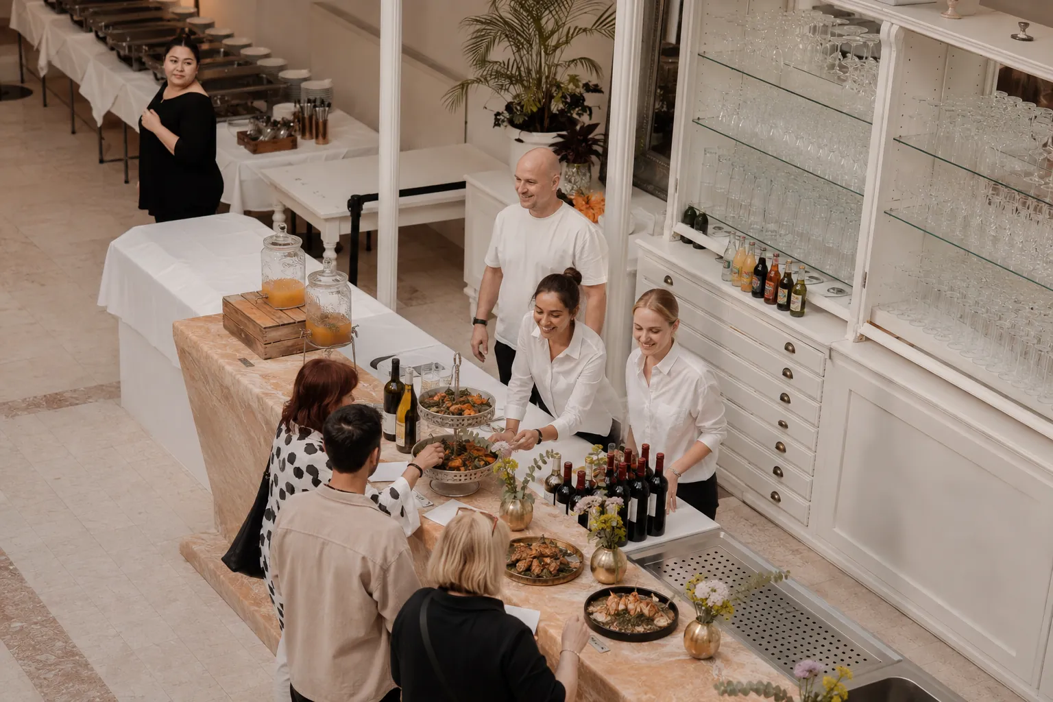 Gäste am Buffet, dahinter das Serviceteam